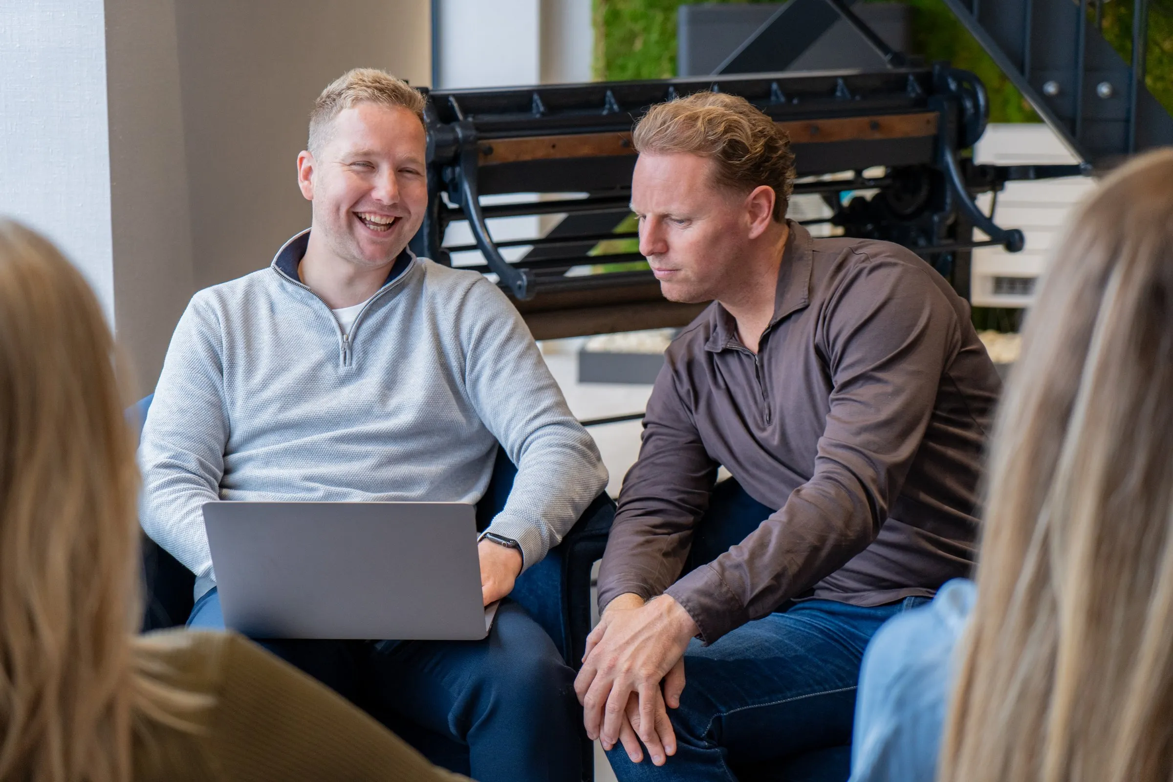 Daan en Tim in overleg met een klant in de lounge